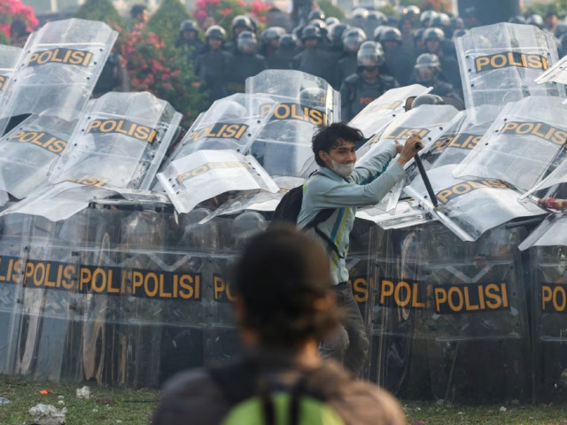 riot police hold shields as people protest outside the indonesian parliament against the revisions to the country s election law which analysts believe goes through a rushed process of legislation and is designed to block a popular candidate from running as the capital s governor in jakarta photo reuter